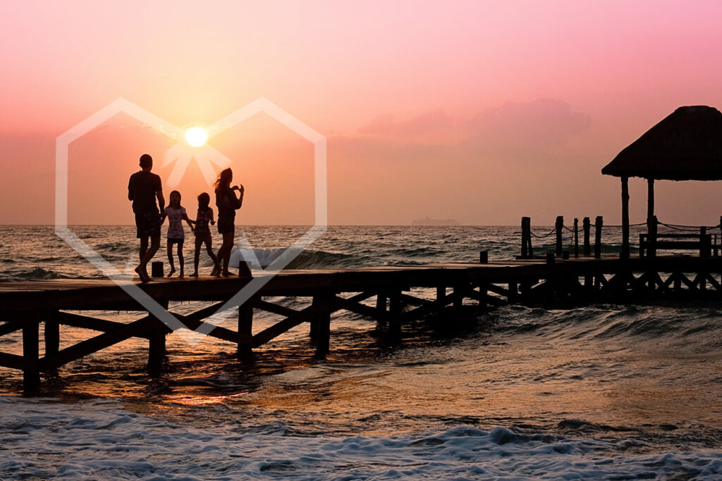 family of four on the beach with sunset